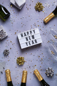 New year pattern with champagne glasses, bottles, sparkles, confetti. view from above