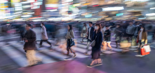 Group of people walking on road in city