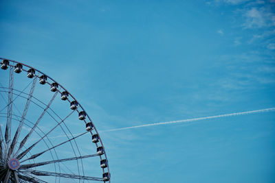 Low angle view of ferris wheel against blue sky