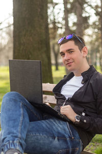 Young man using laptop in park