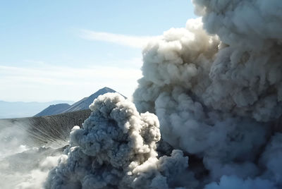 Smoke emitting from volcanic mountain against sky