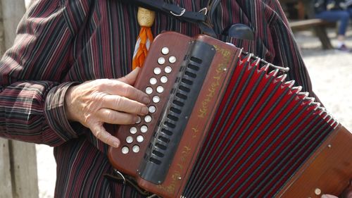 Midsection of man playing accordion