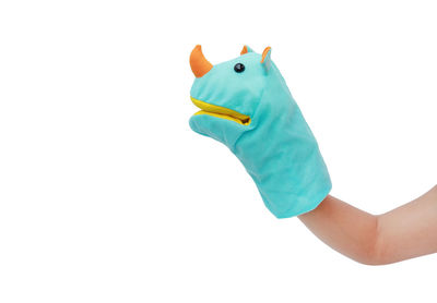 Close-up of hand holding toy against white background
