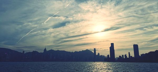 Panoramic view of sea and buildings against sky during sunset