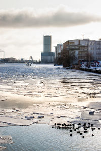 View of city by sea against sky