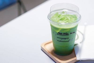 Iced matcha green tea latte on table in store.