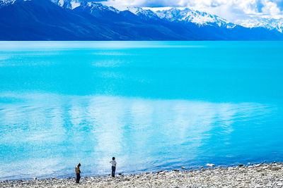 High angle view of friends standing by lake