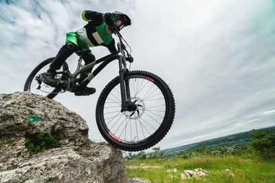 Brave cyclist goes down the rocks. test site for mountain bikers. a guy in protection rides off-road