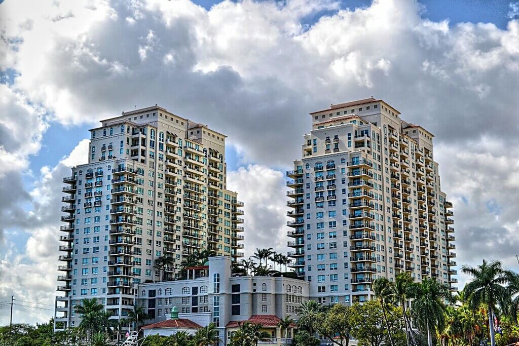 architecture, building exterior, built structure, sky, low angle view, cloud - sky, city, modern, tall - high, tower, cloud, cloudy, office building, skyscraper, building, tree, glass - material, day, outdoors, tall