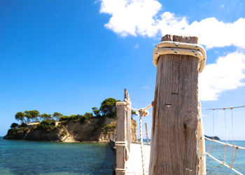 Footbridge over sea against sky