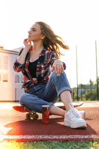 Beautiful young woman looking away while sitting outdoors