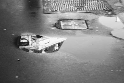 Reflection of building in puddle on street