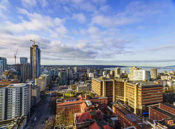 View of buildings in city against cloudy sky