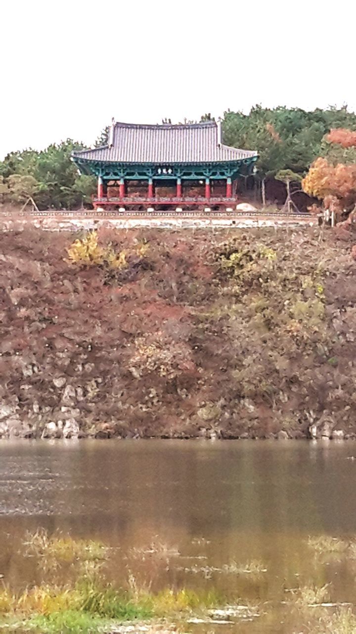 water, built structure, architecture, building exterior, tree, clear sky, house, lake, waterfront, tranquility, nature, scenics, tranquil scene, river, beauty in nature, day, mountain, outdoors, reflection, plant