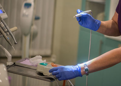 Cropped hand of female doctor examining dental equipment at hospital