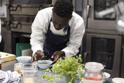 Chef garnishing soup in restaurant kitchen