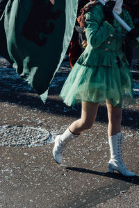 Low section of woman with flag walking on road