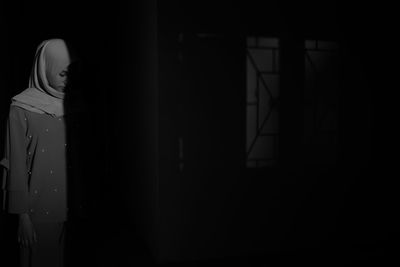Silhouette man standing by door at home