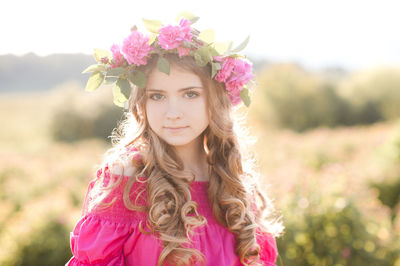 Portrait of teenager girl wearing wreath at farm