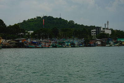 Scenic view of sea by buildings against sky