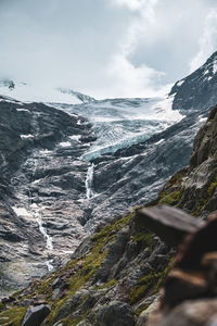 Scenic view of rocky mountains with glacier against  sky