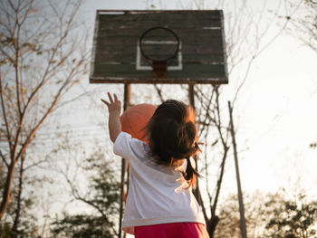 Rear view of girl playing basketball
