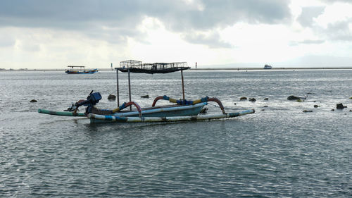 Men fishing in sea against sky
