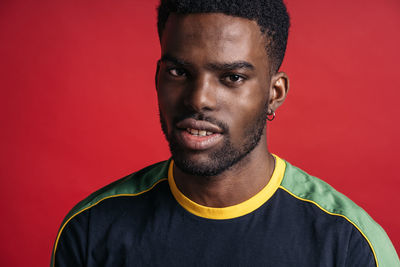 Portrait of young man against red background