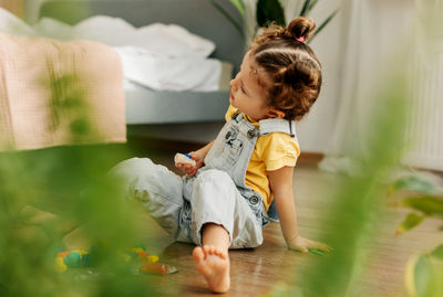 Side view of mother and daughter sitting on floor