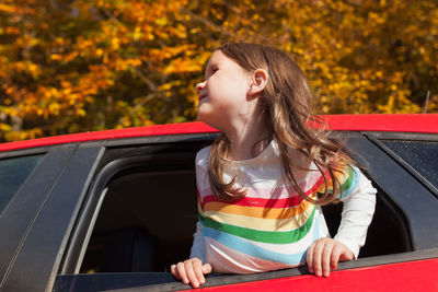 Girl looking away while sitting in car