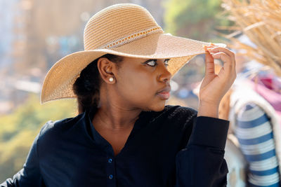Portrait of beautiful african american model girl in stylish sun hat. fashion black woman on natural 