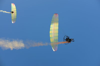 Low angle view of person paragliding against sky