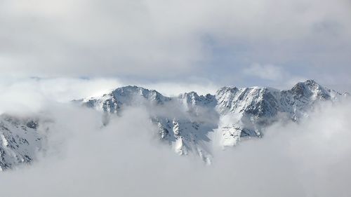 Scenic view of snowcapped mountains against cloudy sky at les arcs