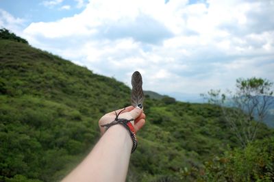 Low section of woman on mountain against sky