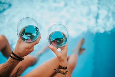Drinking wine by the pool.two glasses of blue wine.