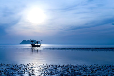 Silhouette boat in sea against sky during sunset