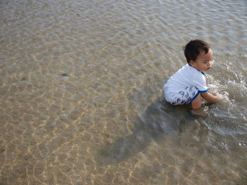 High angle view of boy playing at beach