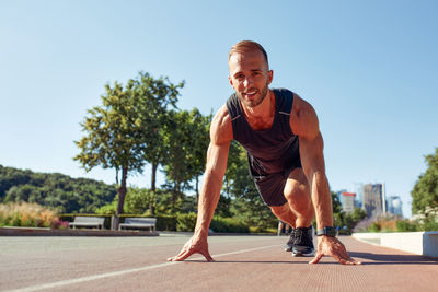 Full length of young man exercising on road