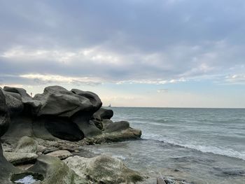Rocks by sea against sky