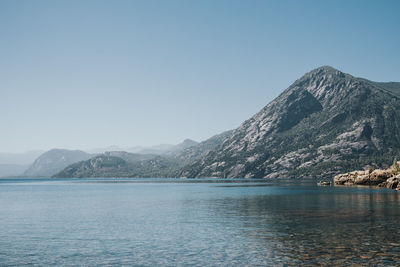 Scenic view of lake and mountains against clear sky