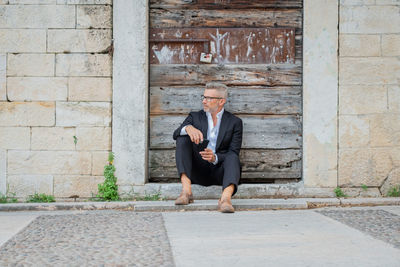 Businessman using mobile phone while sitting outdoors