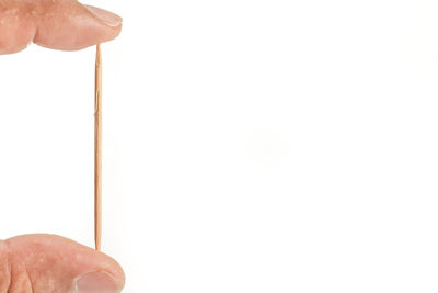 Close-up of hand holding paper against white background
