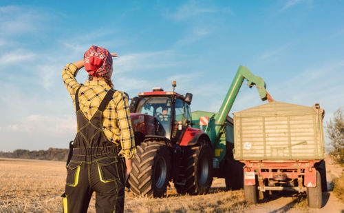 Man and tractor on field against sky