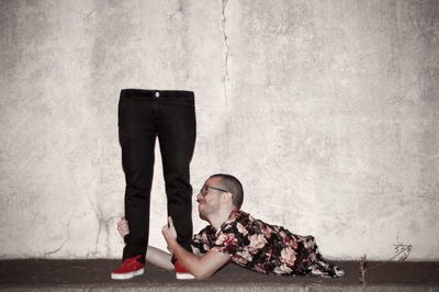 Low section of man on concrete wall