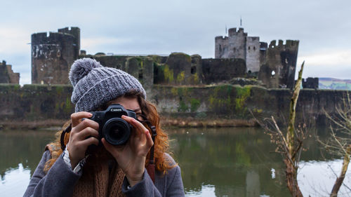 Man photographing with cityscape against sky
