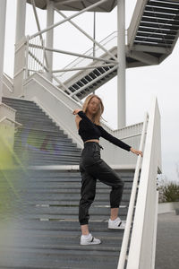 Full length of woman standing on staircase