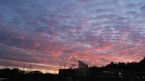 Silhouette of buildings against cloudy sky