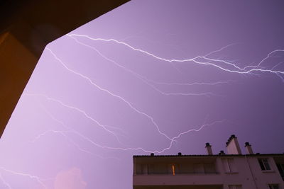 Low angle view of lightning against buildings at night