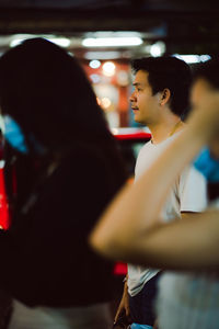 Side view of man and woman looking at camera