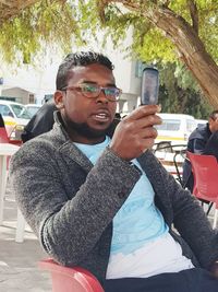 Midsection of man holding smart phone